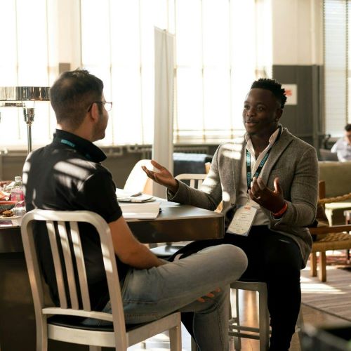 a diverse group of professionals engaged in a collaborative discussion around a table in a bright, modern workspace.